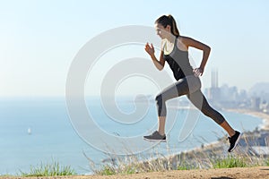 Runner woman running in city outskirts a sunny day