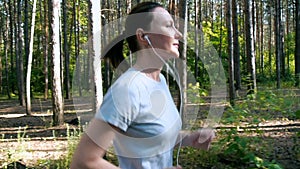 Runner woman running in park exercising outdoors fitness tracker wearable technology girl running in the woods in the