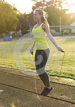 Runner woman running in stadium exercising outdoors fitness tracker wearable technology