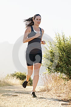 Runner, woman and running on trail with fitness for sport, training or exercise for competition on mountain. Athlete