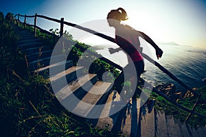 Runner woman running upstairs on sunrise seaside