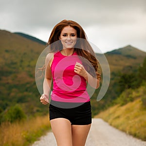 Runner - woman runns on a forest road - outdoor workout