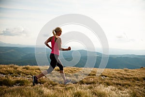 Runner - woman runs cros country on a path in early autumn