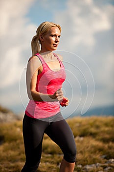 Runner - woman runs cros country on a path in early autumn