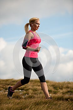 Runner - woman runs cros country on a path in early autumn