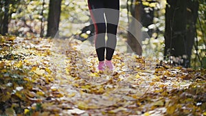 Runner young girl feet running on autumn road closeup on shoe. Female fitness-bikini model outdoors fall jogging on a
