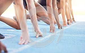 Runners with hands on start line on the track for a race, ready to run. Racing challenge or sprint at sports event with