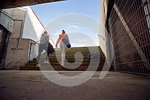 Runners holds sport bag and going at training on stadium