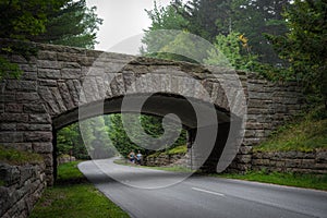 Runners Pass Under Historic Stone Bridge in Acadia National Park