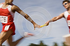 Runners Passing Baton In Relay Race photo