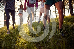 Runners running fast through the forest on trail marathon run