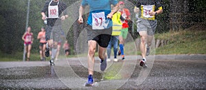 Runners running under rain drops city marathon
