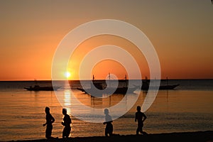 Runners silhouette at sunset. White beach. Boracay Island. Aklan. Western Visayas. Philippines