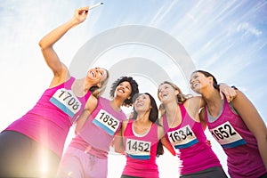 Runners supporting breast cancer marathon and taking selfies