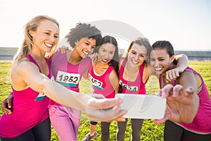 Runners supporting breast cancer marathon and taking selfies