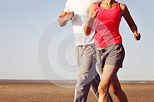 Runners training outdoors working out in nature against blue sky