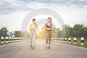 Runners - two women running outdoors training. Exercising female