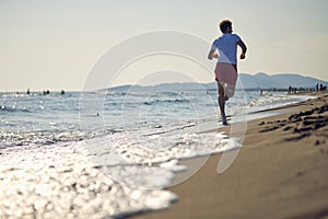 Runners. Young people running on beach. Athletic people jogging on beach enjoying the sun exercising their healthy lifestyle