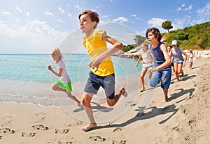 Running along the sea water group of kids