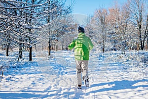 Running athlete man sprinting in winter forest. Training outside in cold snowy weather. Active healthy way of life