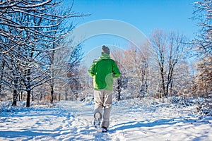 Running athlete man sprinting in winter forest. Training outside in snowy weather. Active healthy way of life. Sport