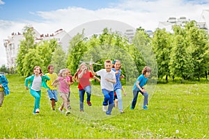 Running boy with airplane toy and children behind