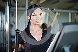 Running brunette in black t-shirt at gym