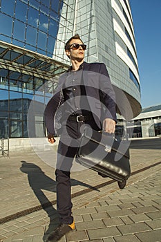 Running businessman with briefcase in hand