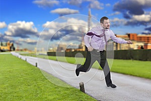 Running businessman in a hurry with modern city in