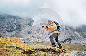 Running caucasian man with backpack and trekking poles by Makalu Barun Park route near Khare. Mera peak climbing acclimatization photo