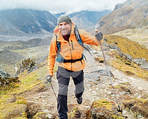 Running caucasian man with backpack and trekking poles by Makalu Barun Park route near Khare. Mera peak climbing acclimatization
