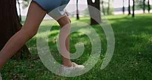 Running children legs on green grass meadow. Unknown kids play jogging outdoors.