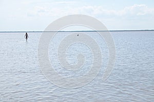 Running children on the surface of lake at summer. Salt shallow lake. Loneliness concept in big world