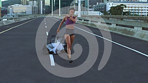 Running, exercise and fitness girl with parachute working on hardcore extreme training for marathon on city road