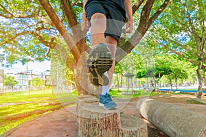 Running feet male view from below in runner jogging exercise with old shoes in public park for health lose weight concept