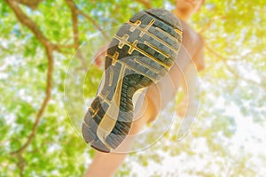 Running feet male view from below in runner jogging exercise with old shoes in public park for health lose weight concept