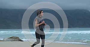 Running female runner jogging during outdoor workout on beach., fitness model