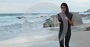 Running female runner jogging during outdoor workout on beach., fitness model