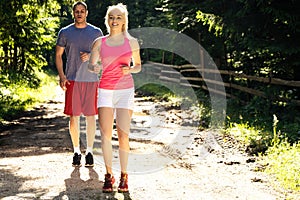 Running fitness couple of runners doing sport on road outdoor. Active living man and woman jogging training cardio