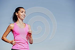 Running fitness woman. Training woman in pink top on a blue background