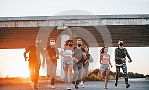 Running forward. Group of young cheerful friends having fun together. Party outdoors