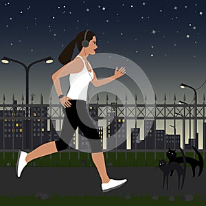 Running girl with headphones in sportswear on the background of the city at night. In the background, there are street lights