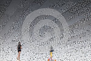 Running girls on the background of a textured wall. Reflection on a wet tile after rain