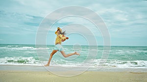 Running happy woman on sandy sea beach, enjoying seascape, feeling freedom.