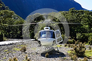 Running helicopter landed on gravel in Campbell`s Kingdom - Fjordland National Park - Doubtful Sound