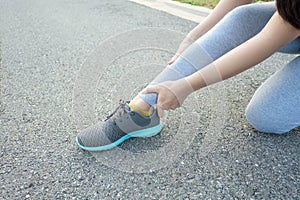Running injury leg accident- sport woman runner hurting holding painful sprained ankle in pain
