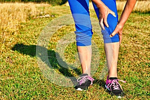 Running injury leg accident- sport woman runner hurting holding painful sprained ankle in pain.