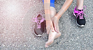 Running injury leg accident- sport woman runner hurting holding painful sprained ankle in pain.