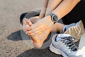 Running injury leg accident- sport woman runner hurting holding painful sprained ankle in pain. Female athlete with joint or