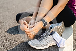 Running injury leg accident- sport woman runner hurting holding painful sprained ankle in pain. Female athlete with joint or